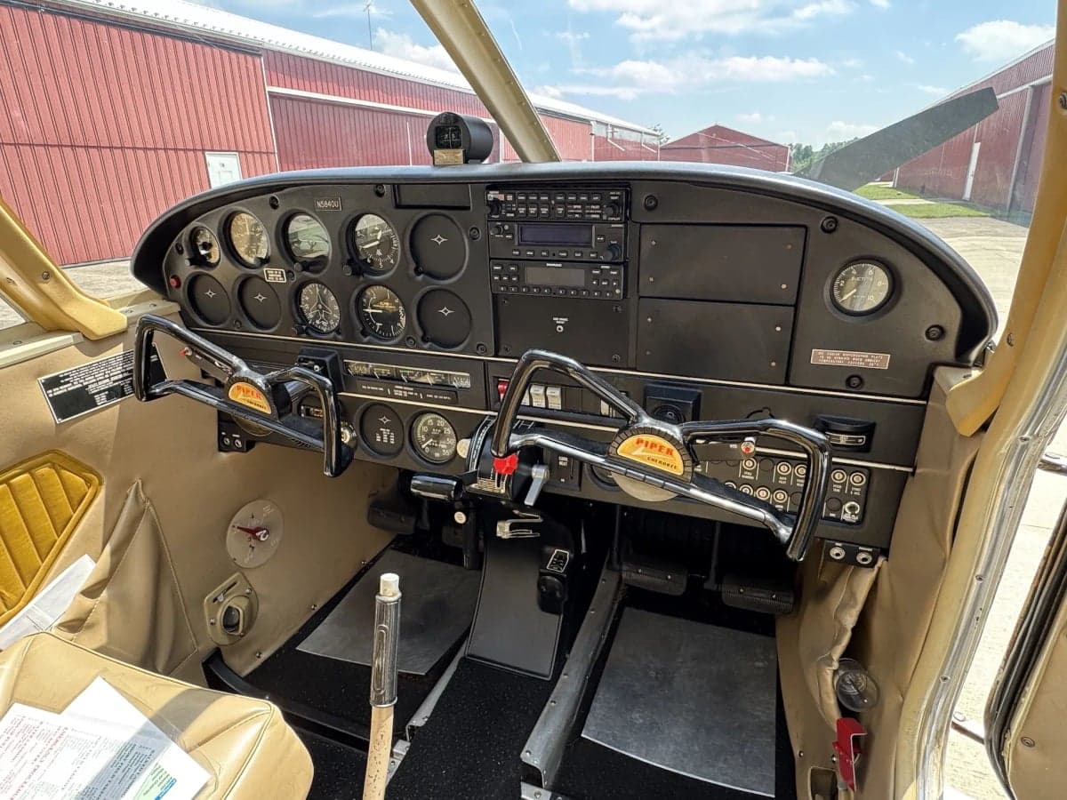 The cockpit of the Piper aircraft, showing the instrument panel and controls.