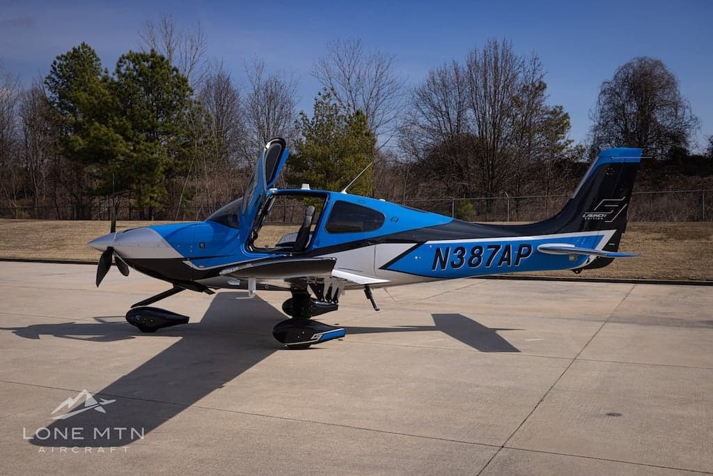 Cirrus SR22T with blue and silver paint scheme on the ramp with doors open.