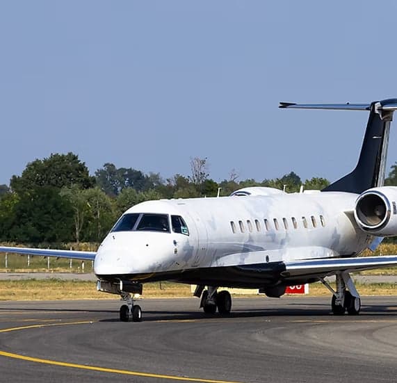 Embraer Legacy 600 on the tarmac with a white and black paint scheme.