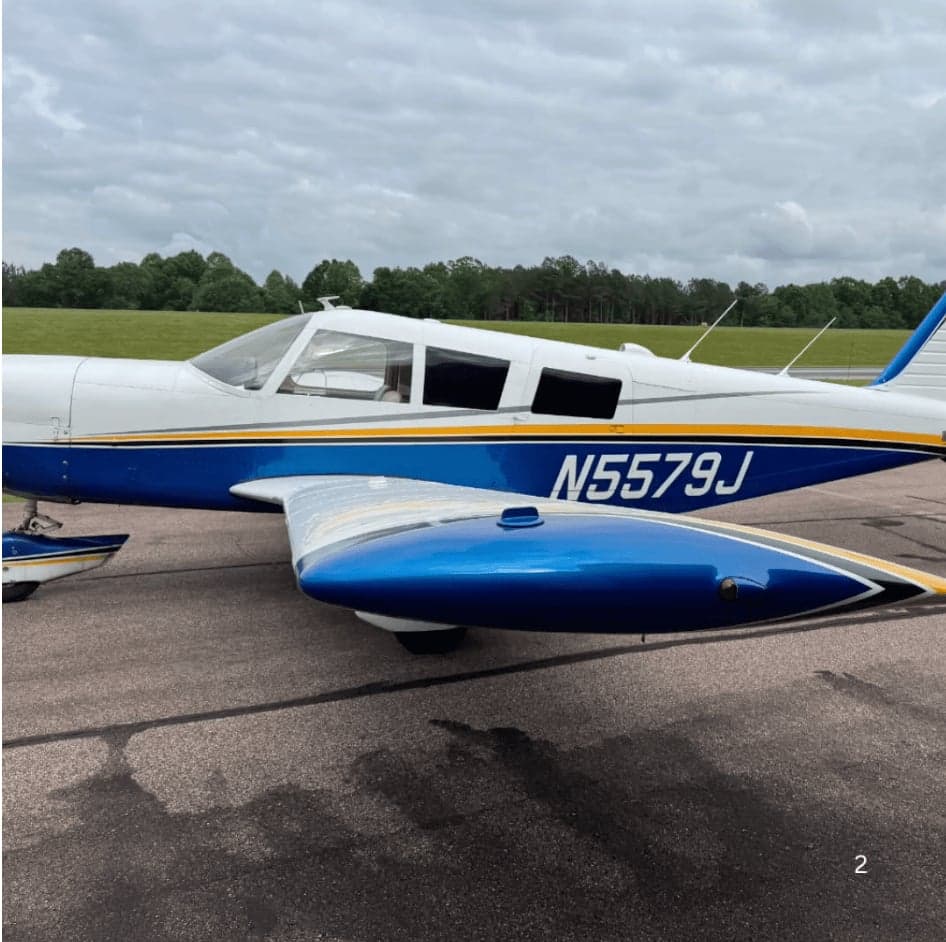 A blue and white aircraft with tail number N5579J parked on the tarmac.