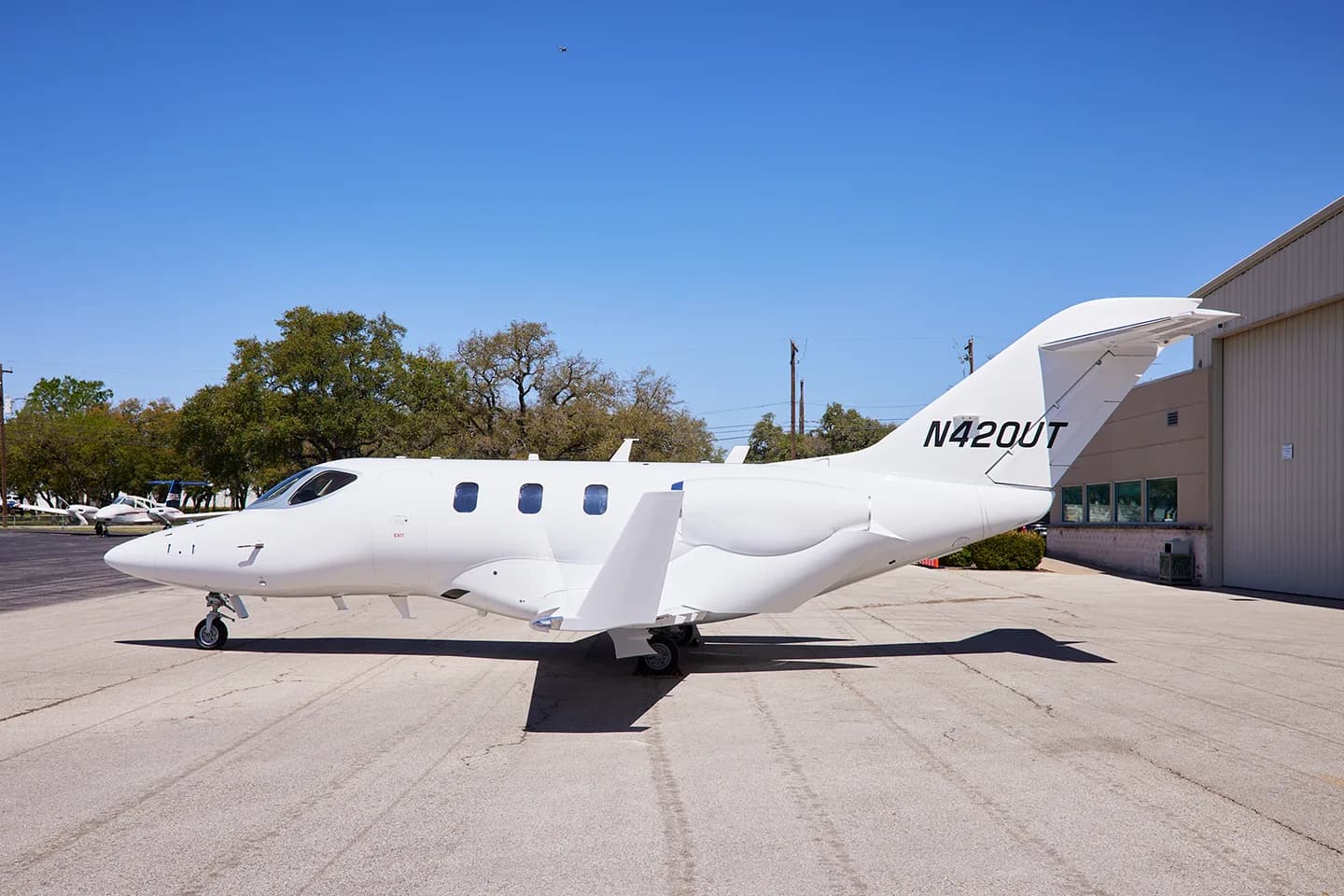 Side view of a white HondaJet N420UT on the tarmac.