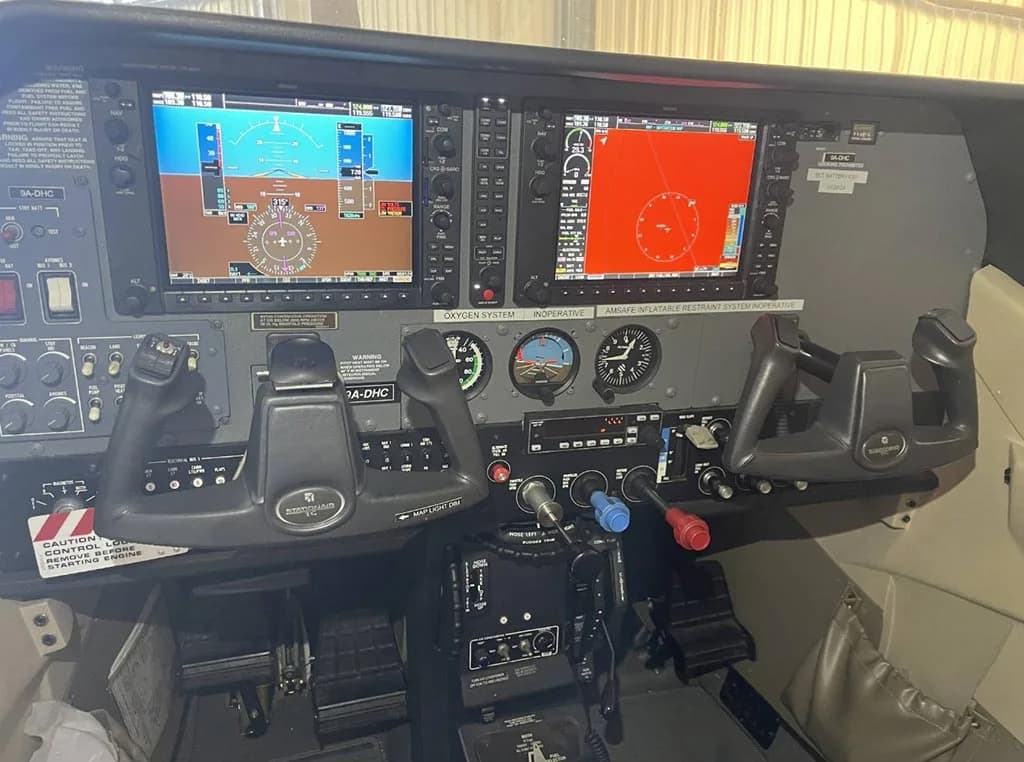 The cockpit instrument panel of the aircraft, featuring two large digital displays and dual yokes.