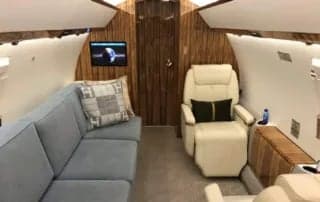 Interior of the aircraft with a couch and recliner.