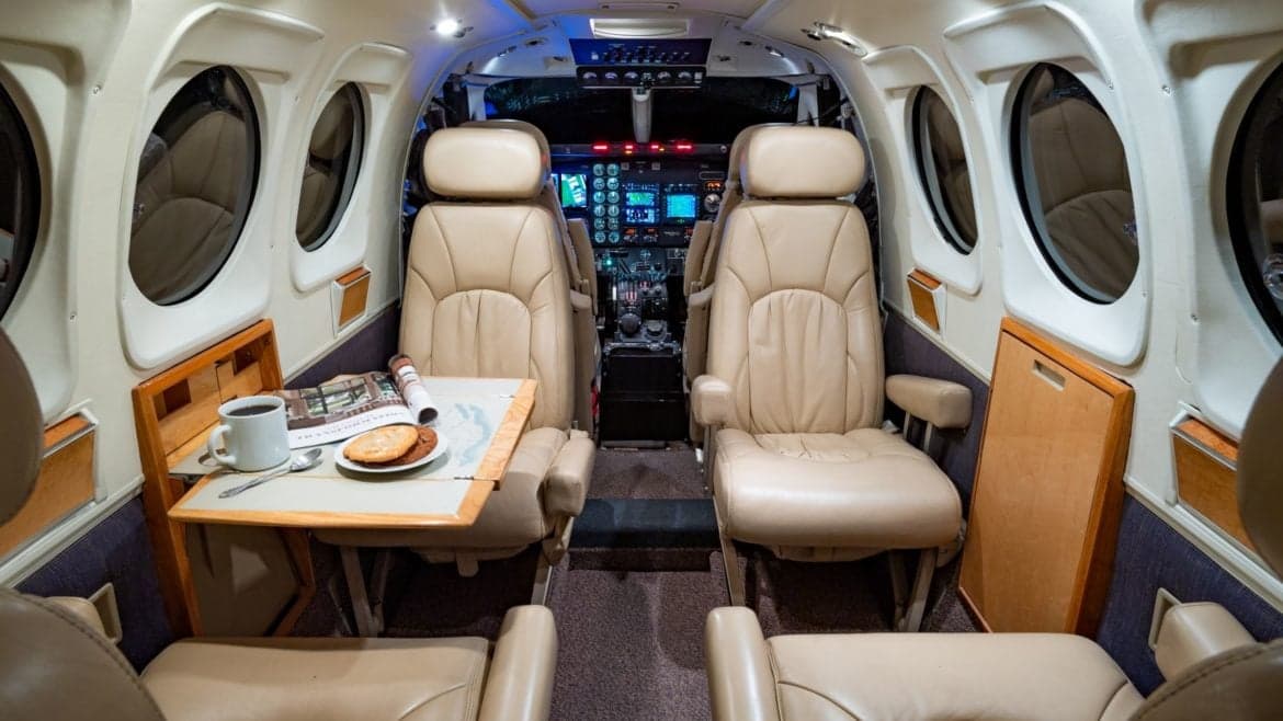 View of the aircraft's cabin with leather seats and a small table.