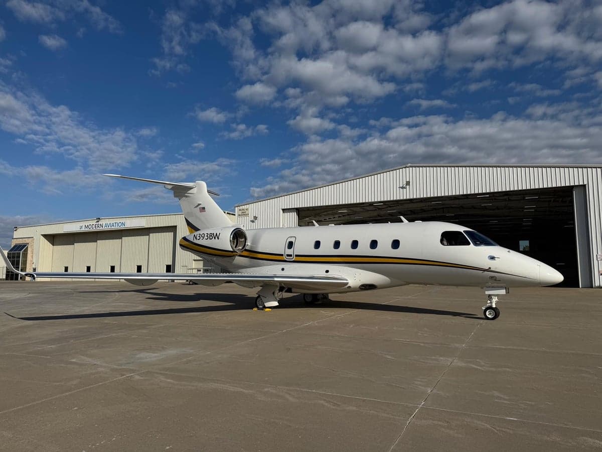 Side view of the aircraft N393BW parked outside a hangar.