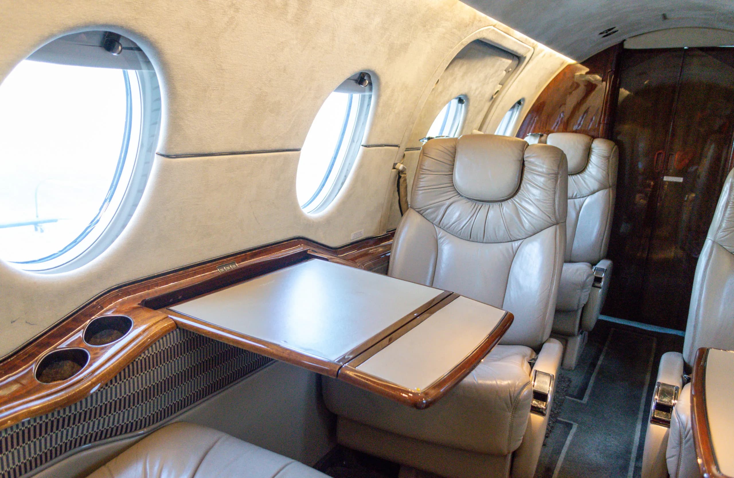 Interior view of the Learjet cabin with leather seats and a table.
