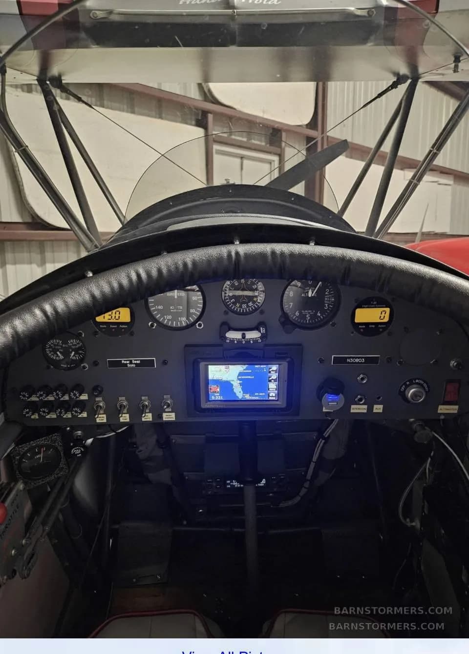 A close-up view of the biplane's instrument panel, featuring analog gauges and a central GPS display.