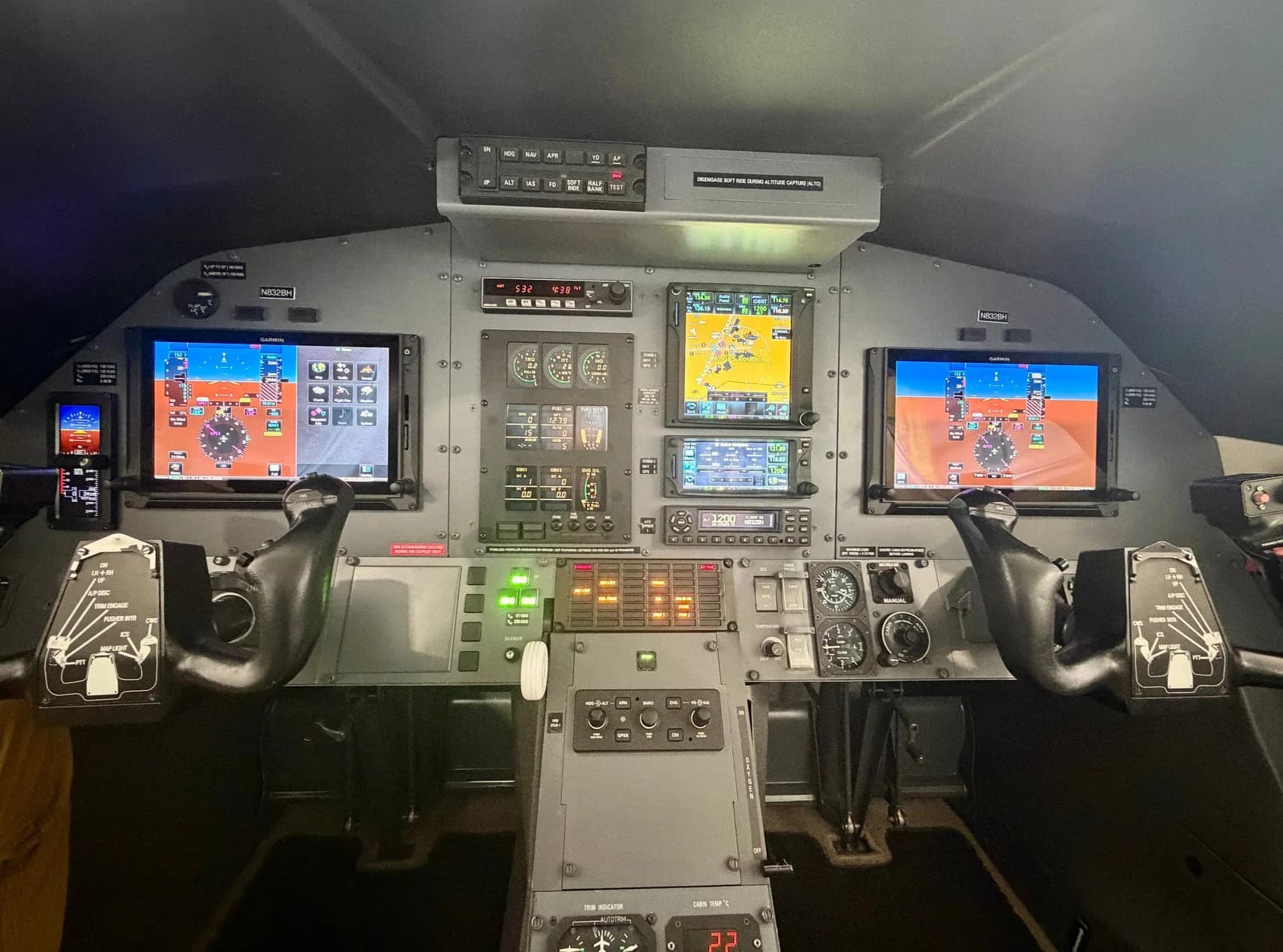 The cockpit of a Pilatus PC-12 aircraft, showing the instrument panel with multiple digital displays and flight controls.