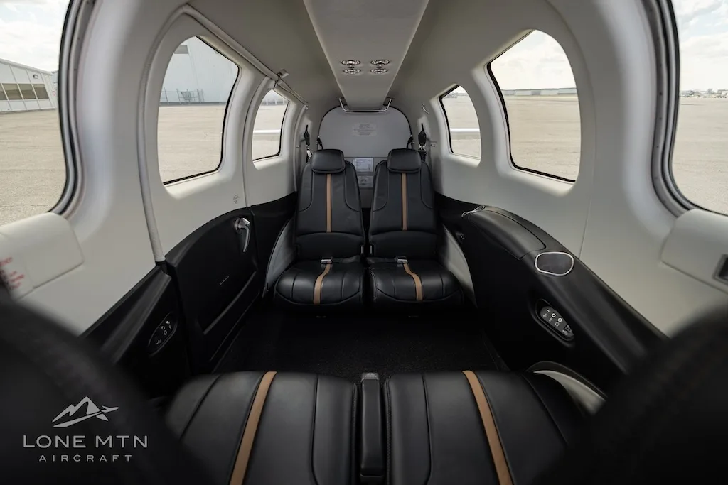 A wide view of the aircraft's interior cabin, featuring black leather seats with tan accents.