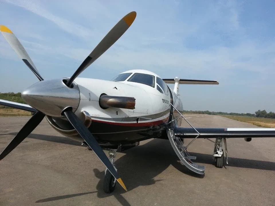 Pilatus PC-12 with the door open on the tarmac.