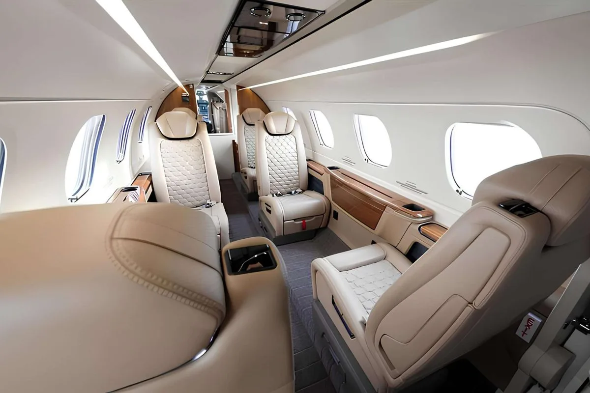 Interior view of the aircraft cabin with leather seats and wood trim.