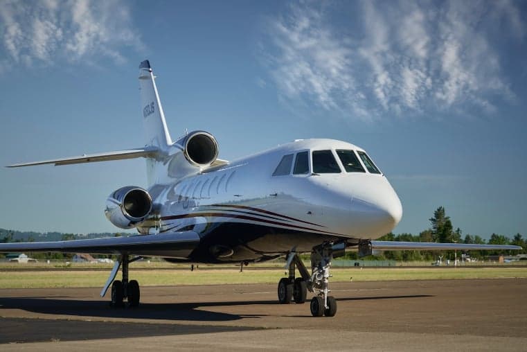 A Falcon 900EX EASy aircraft with registration N955JG parked on the tarmac.
