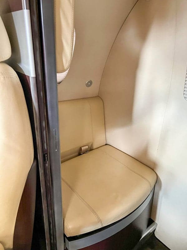 A close-up of a seat inside the Phenom 100 aircraft's cabin.
