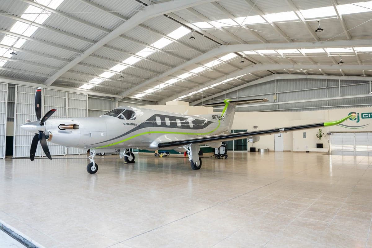Pilatus PC-12 aircraft with registration N676SG parked in a hangar.