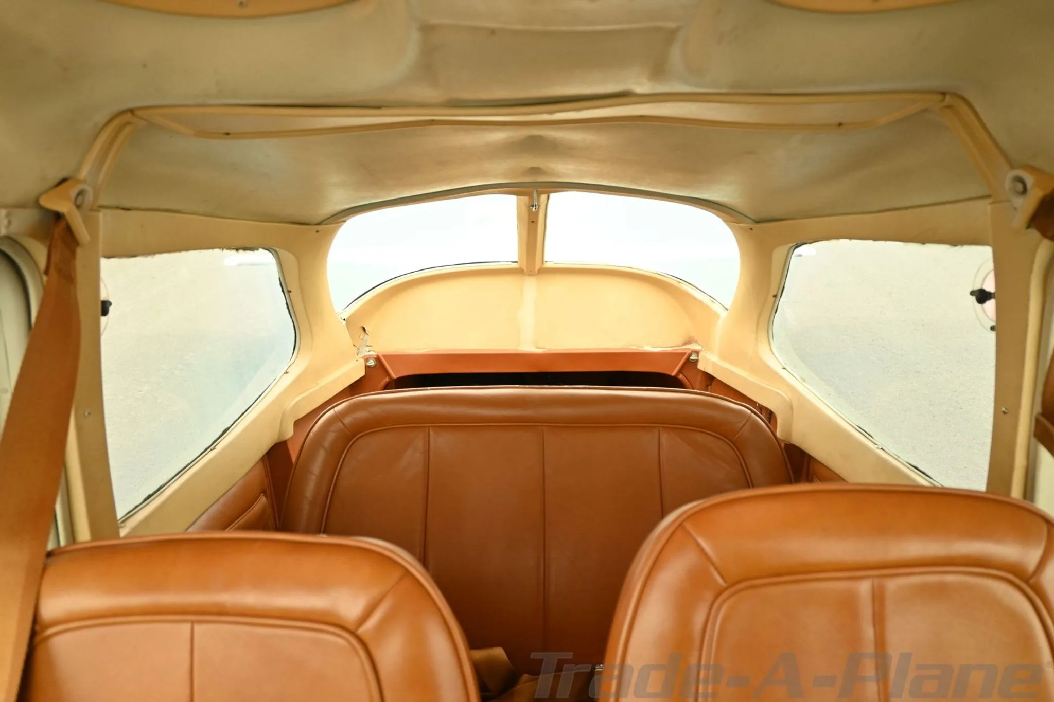 The tan leather rear seats of a Cessna 172 Hawk XP II aircraft cabin.