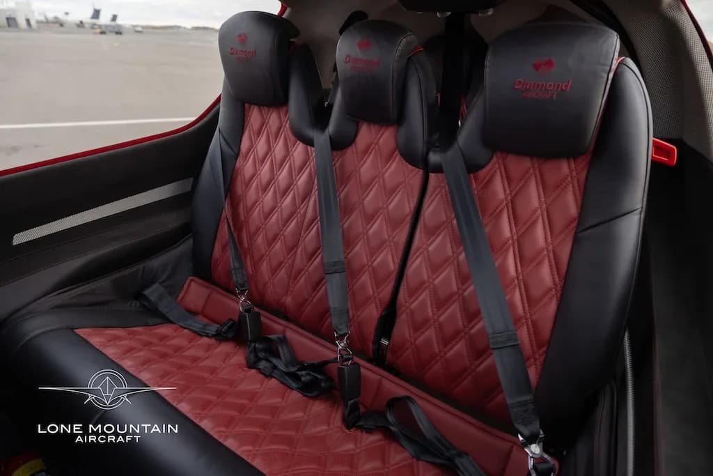 The red quilted leather and black rear passenger seats of the Diamond DA62 cabin.