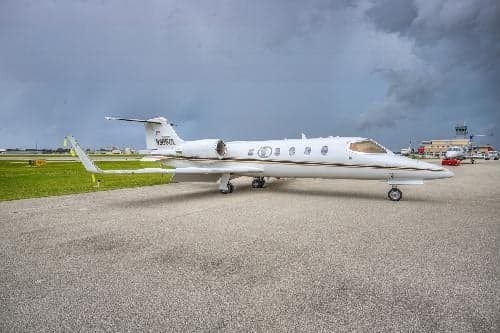 A Learjet 31A, registration N365GL, sits on the tarmac on a cloudy day.