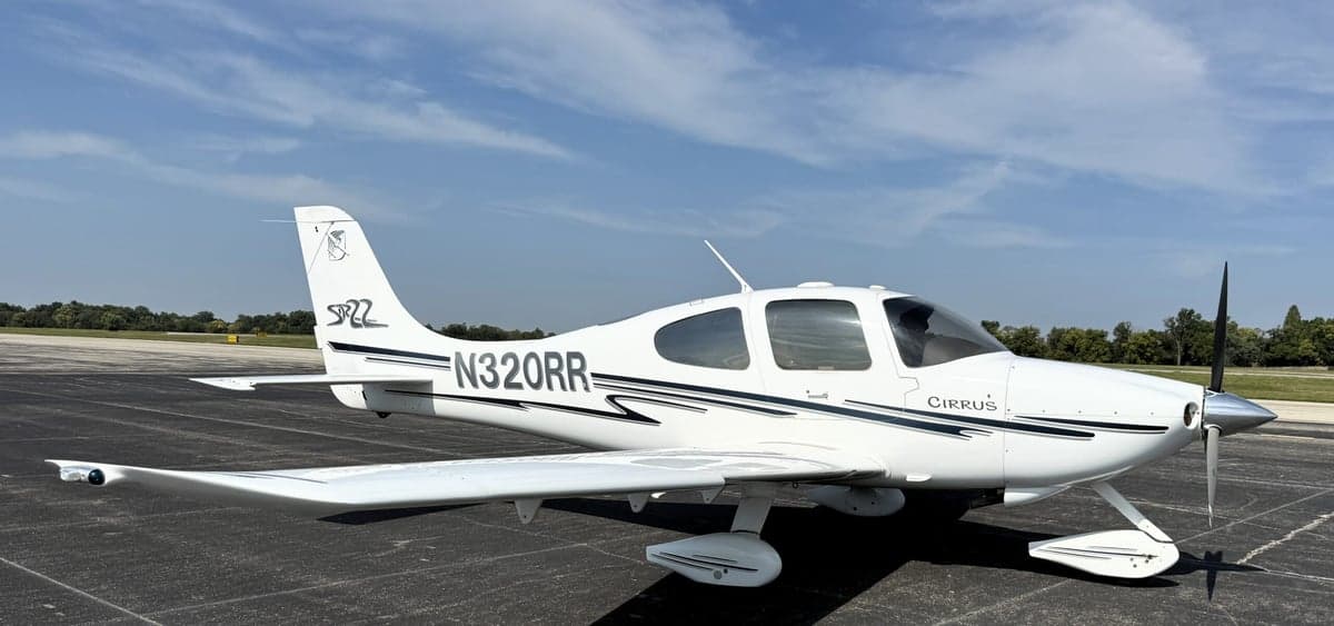 A Cirrus SR22 aircraft with registration N320RR is parked on the tarmac.