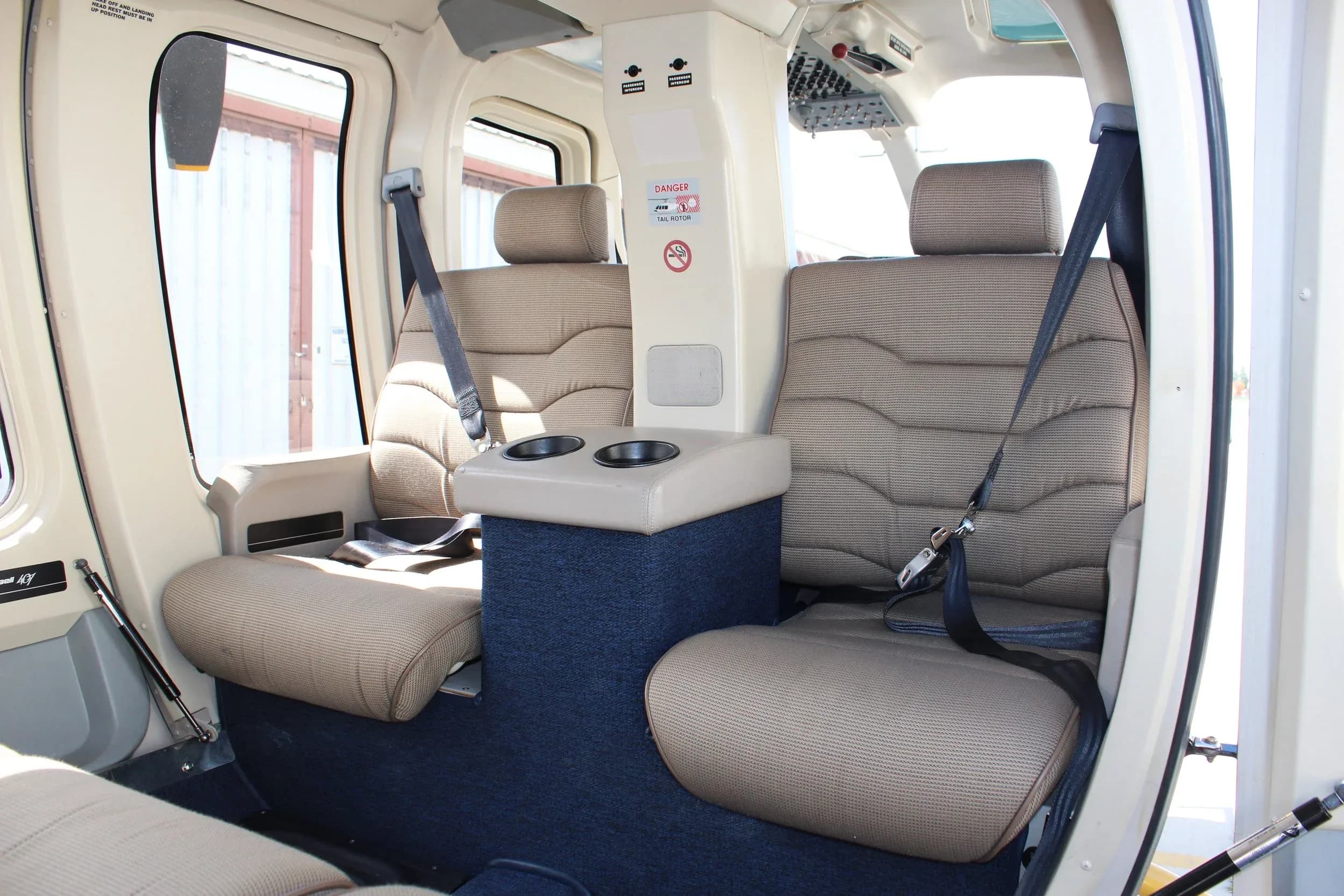 The interior of a helicopter with four seats and a center console.