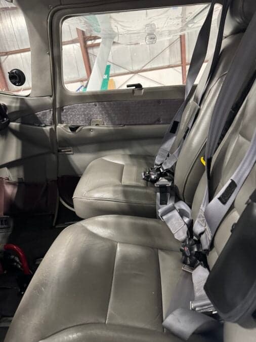 The interior of the Cessna 206 shows the seats and seatbelts.