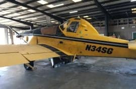 A close up of a yellow Air Tractor crop duster in a hangar.