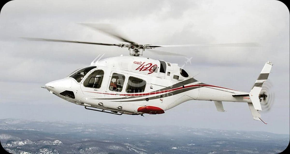 A white AgustaWestland AW169 helicopter in flight over a snowy landscape.