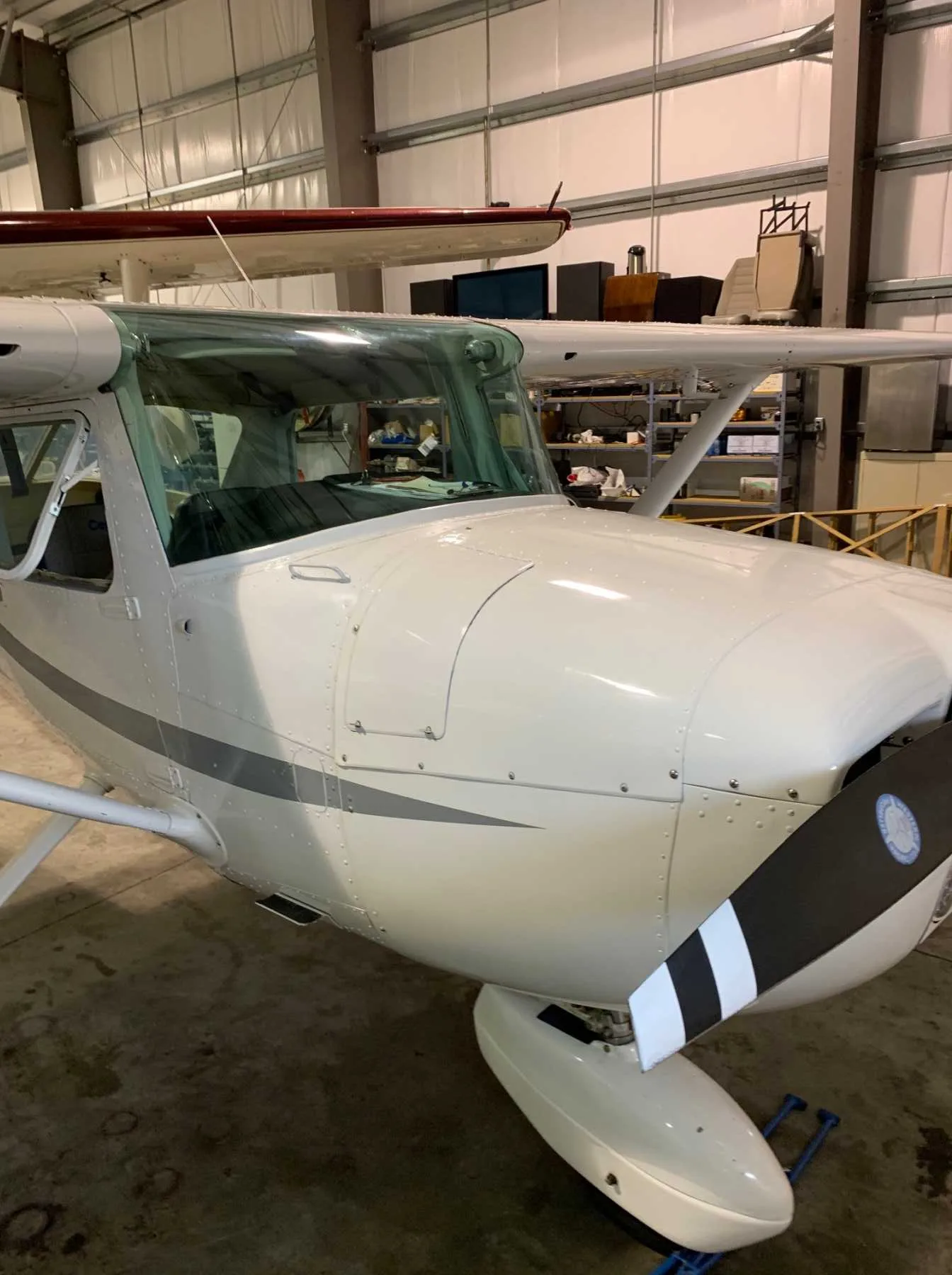 Close up of the front of a Cessna 172 Skyhawk in a hangar.