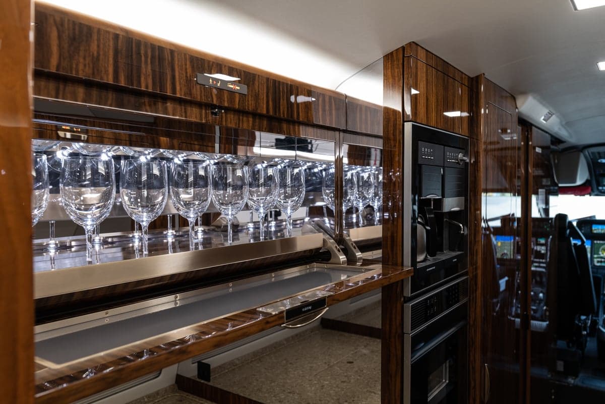 The aircraft's interior includes a bar area with glassware and appliances.