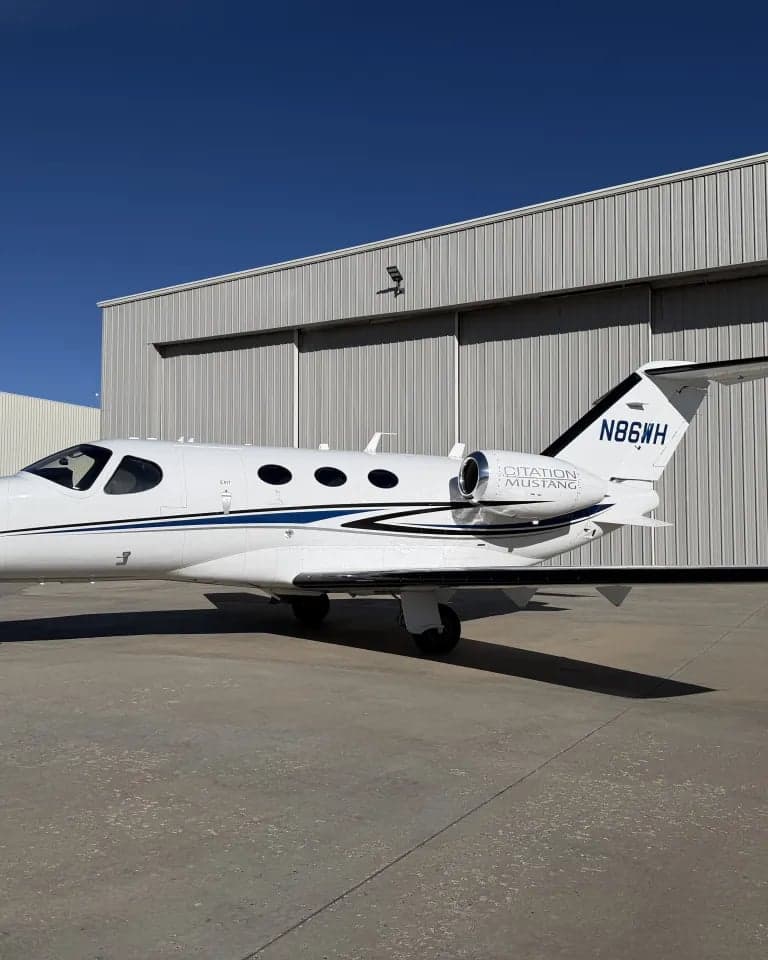 A Citation Mustang aircraft parked on the tarmac, showing the tail number N86WH.