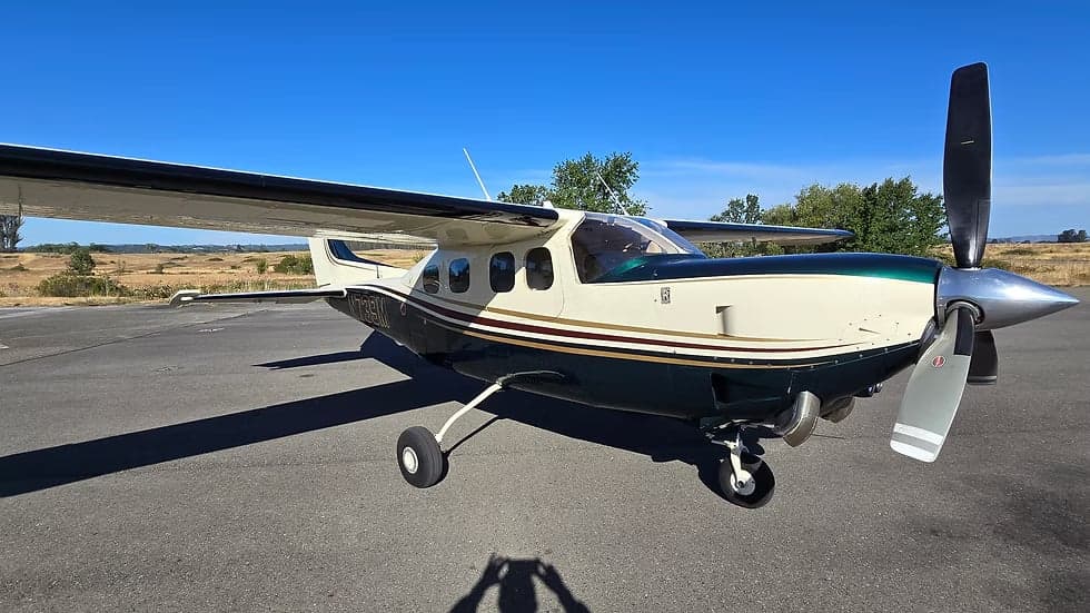 A Cessna 208 Caravan aircraft with a white and green paint scheme is parked on the tarmac.