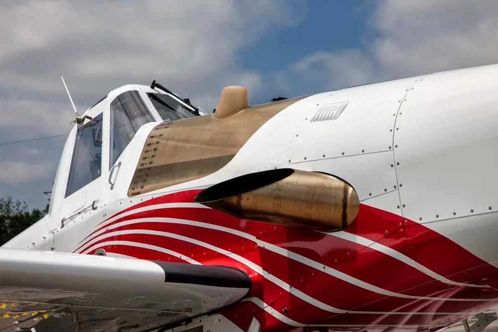 Close-up of the engine and cockpit of an Air Tractor crop duster with red and white paint.