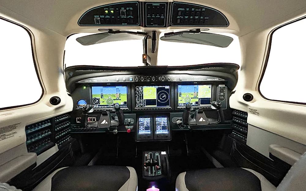 The modern glass cockpit of the Piper M600/SLS, featuring multiple large digital displays and controls.