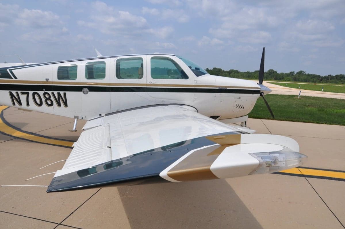 Close up of the wing and forward fuselage of a Beechcraft Bonanza aircraft.