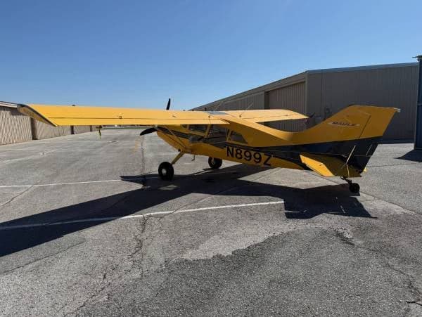 A yellow and blue Maule M-7-235 aircraft with registration N899Z parked on the tarmac.