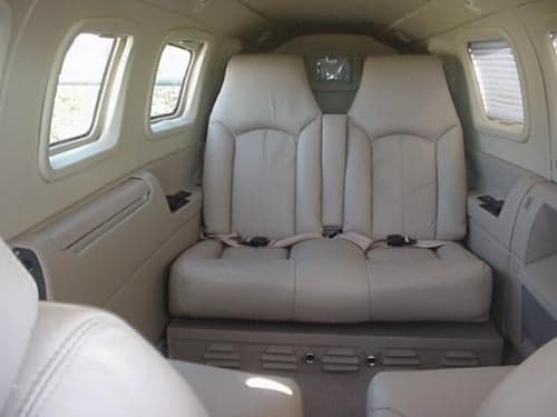 The interior of the aircraft features cream-colored leather seats.