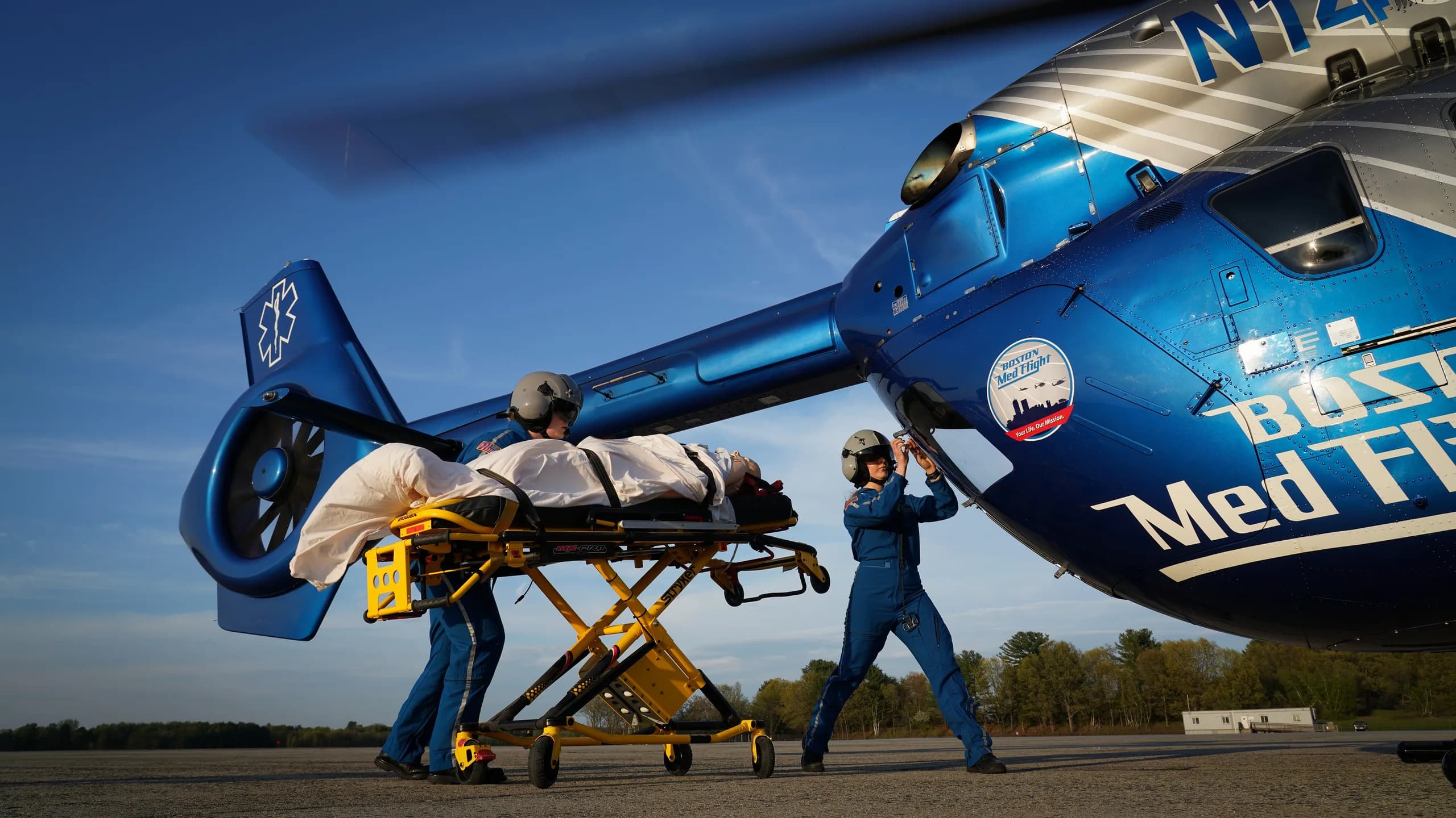 A Boston MedFlight helicopter with medical personnel and a patient on a stretcher.