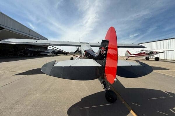 Rear view of the gray and red N413SM aircraft parked on the tarmac.