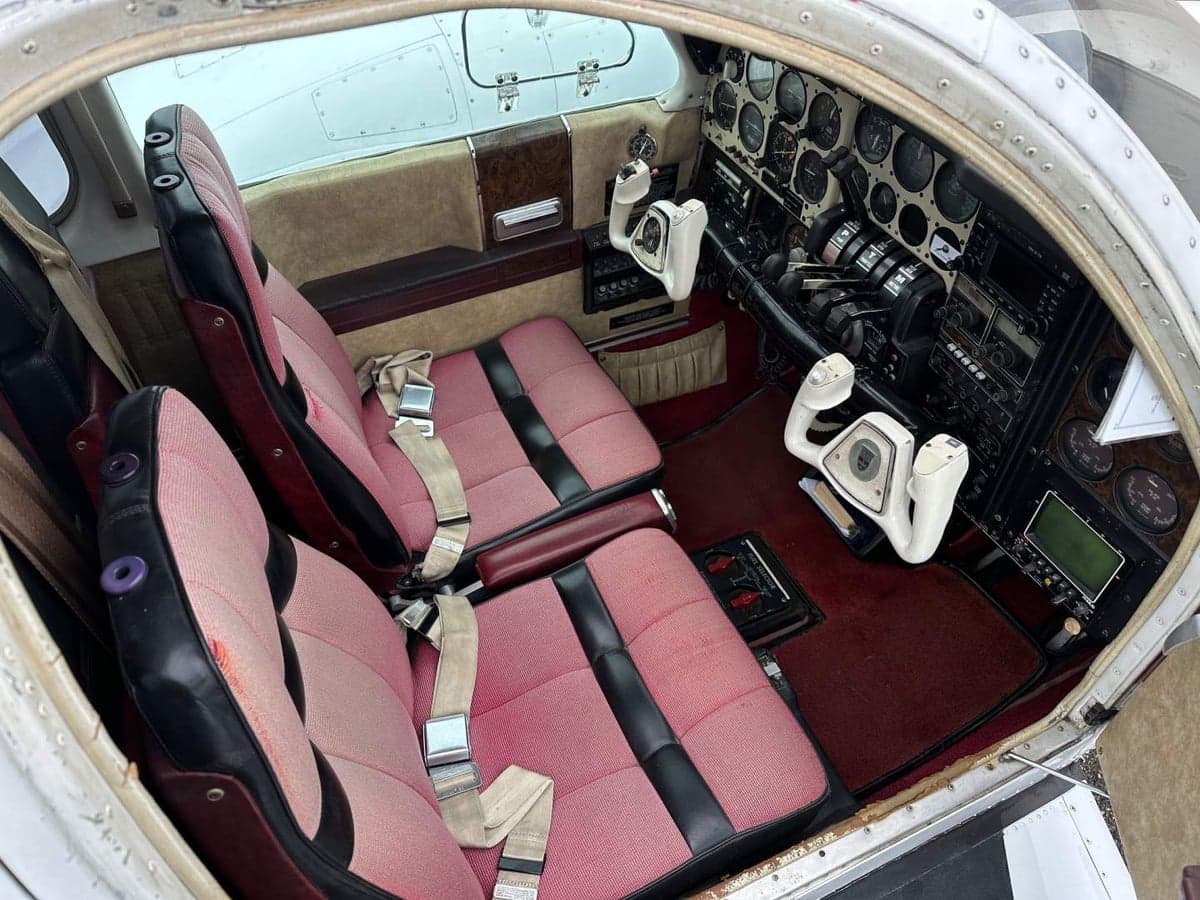 The interior of the aircraft features red seats and a brown dashboard.