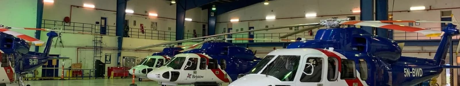Several Bristol helicopters parked inside a hangar.