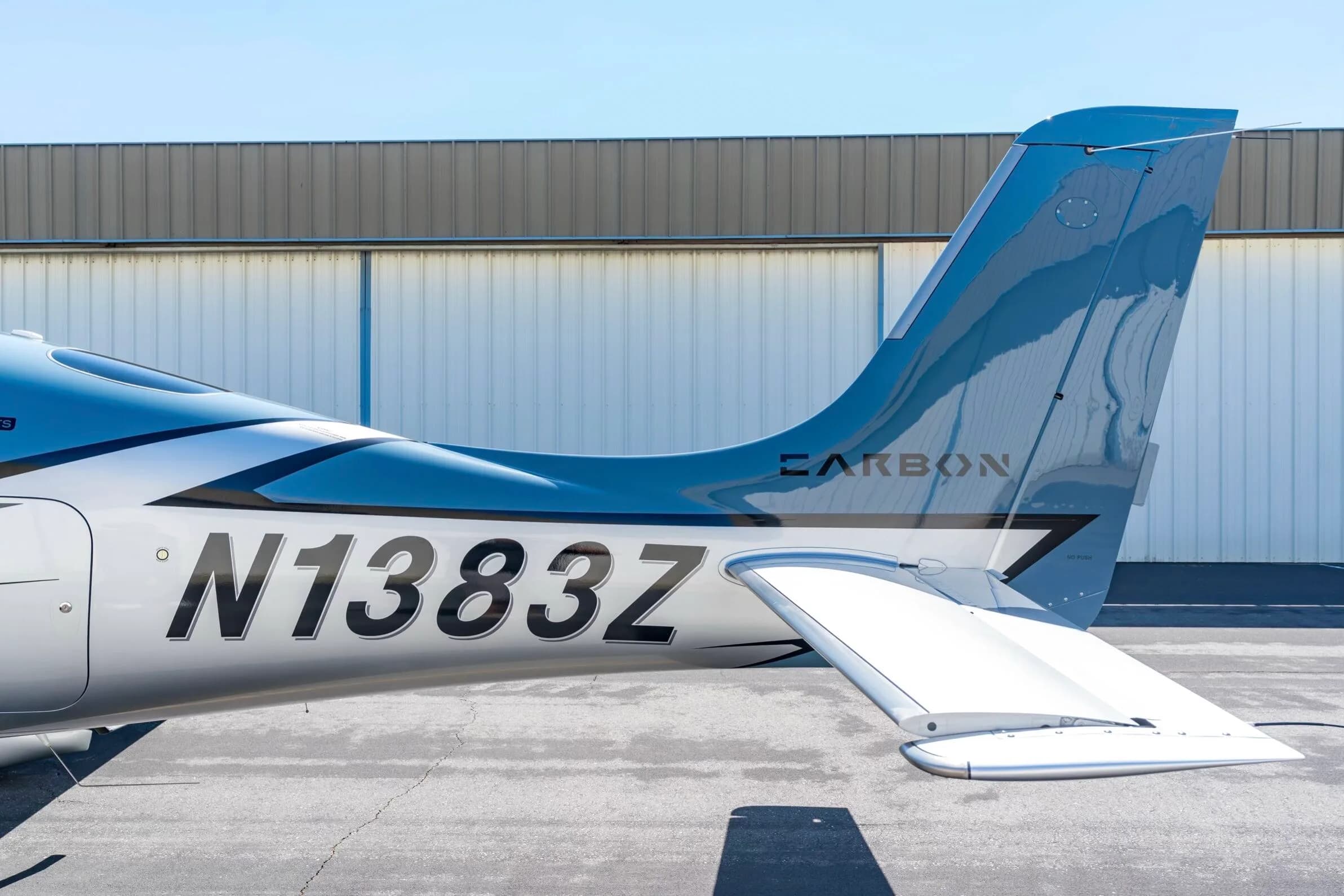 Close-up of the tail section of a light blue and silver Cirrus SR22T aircraft, N1383Z, showing the registration.