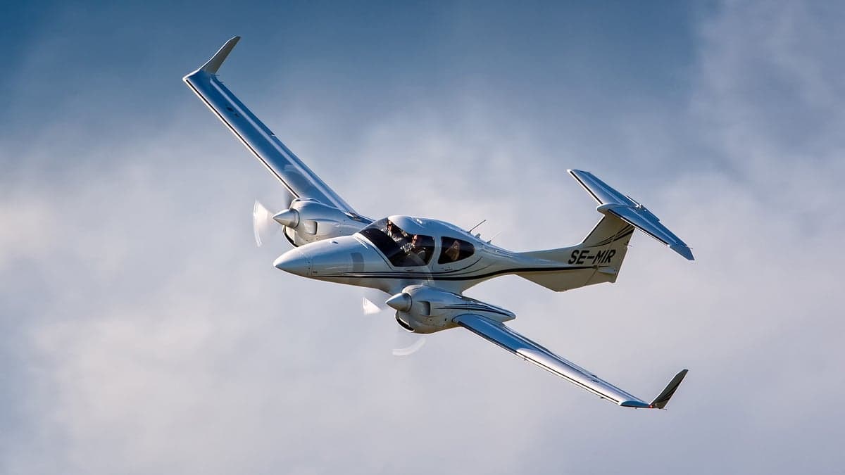 Diamond DA62 aircraft in flight against a blue sky.