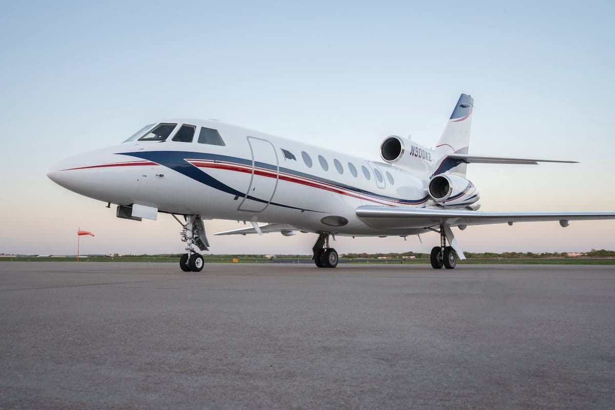A Falcon 50 aircraft with registration N900KE is parked on the tarmac.