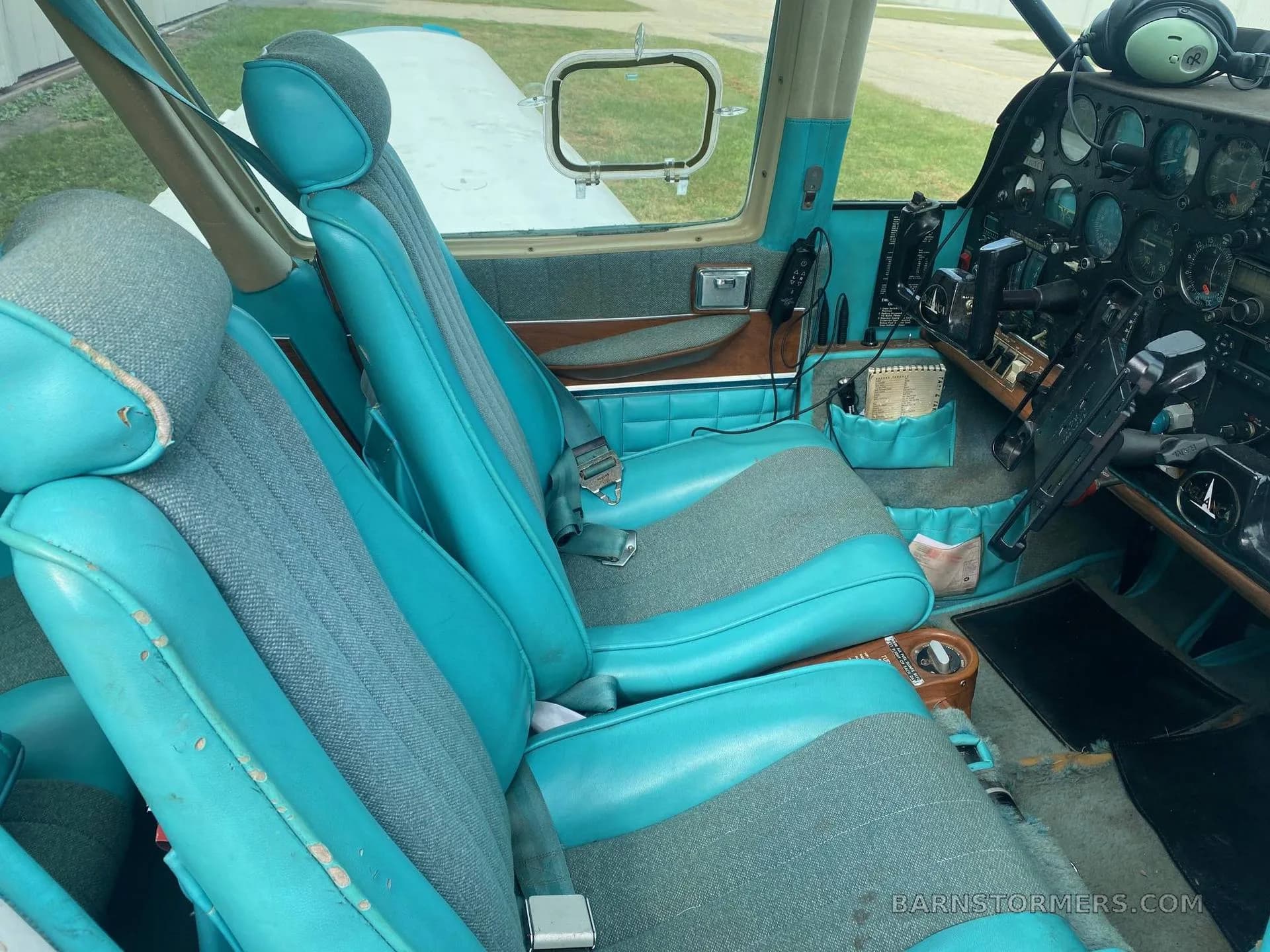 The front cabin interior of the Bellanca aircraft, featuring blue and grey fabric seats and a partial view of the instrument panel.