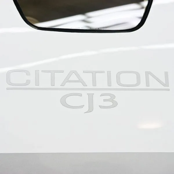 A close-up of the text "CITATION CJ3" embossed on the white fuselage of an aircraft.