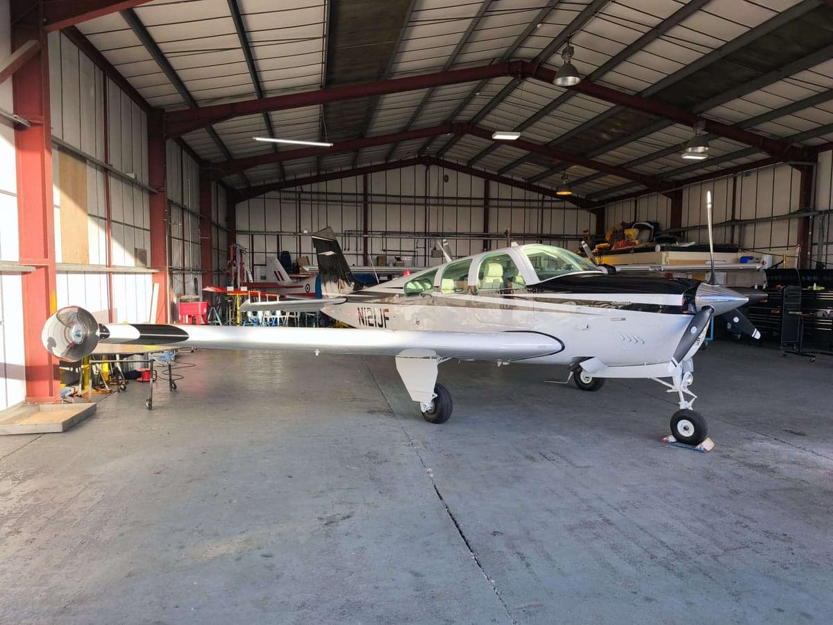 A Beechcraft Bonanza parked inside a hangar.