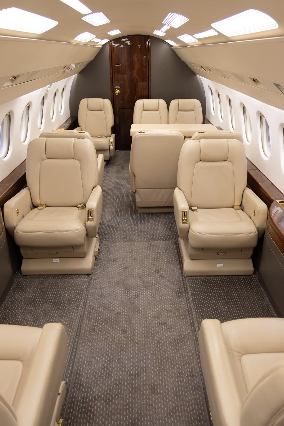 A view of the aircraft's interior, featuring beige leather seats and a central aisle.