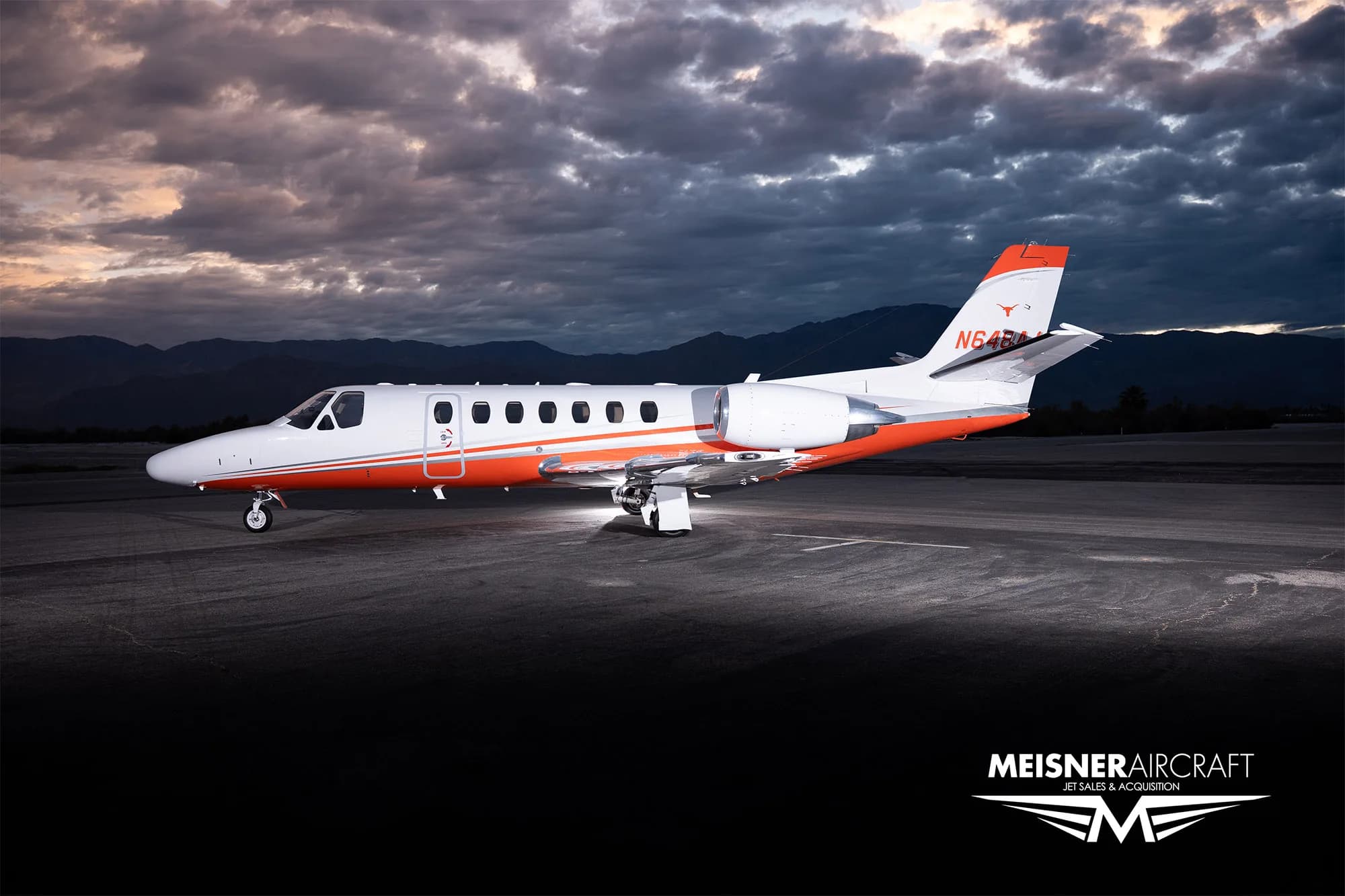 Cessna Citation Encore with orange stripe at dusk.