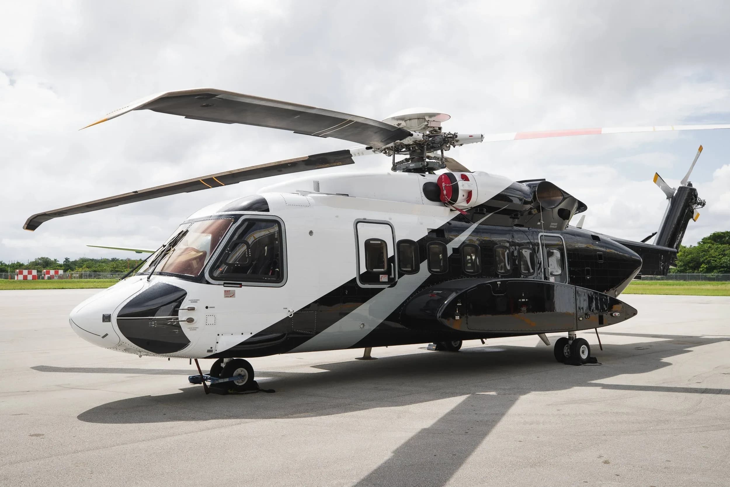 A black and white helicopter is parked on the tarmac.