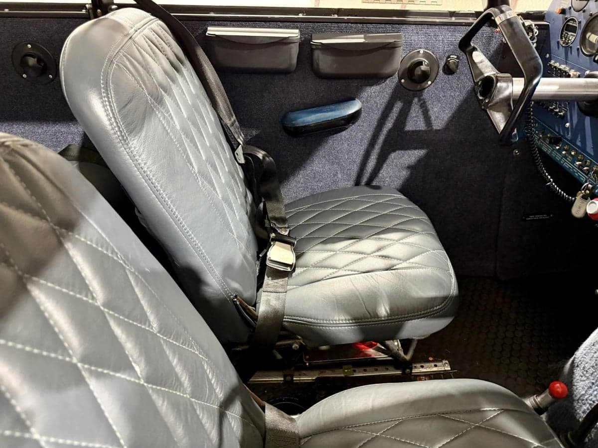 The interior of the Piper PA-28-140 Cherokee features gray leather seats with diamond stitching.