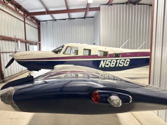 A view of the Piper Saratoga II TC (N581SG) from behind the wing, highlighting the wingtip light.